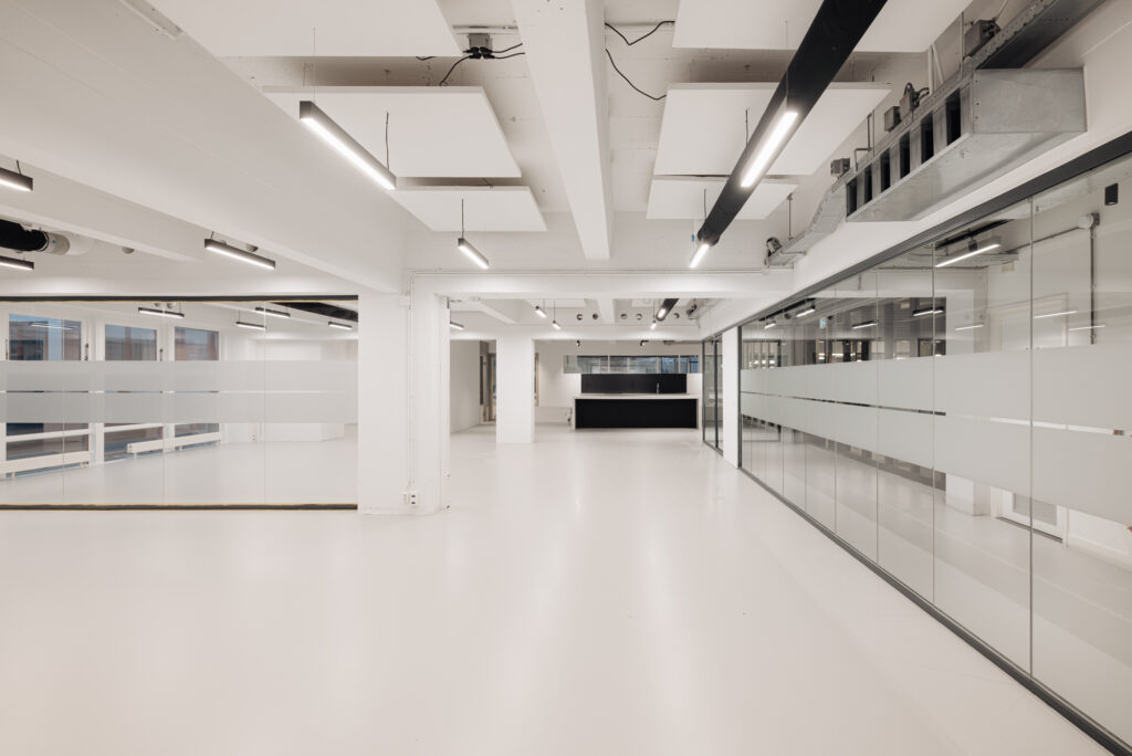 Modern, licht en leeg kantoorinterieur aan de Generaal Vetterstraat met glazen wanden en zichtbare plafondinstallaties.